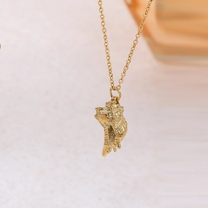 Macro shot of gold shell pendant necklace showing intricate spiral texture and fine chain