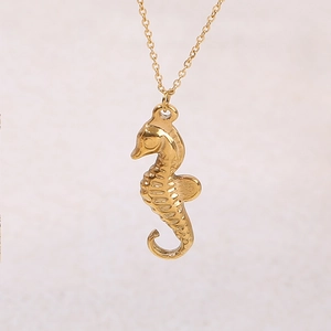Detailed view of the gold seahorse pendant showing intricate scale textures on the link chain