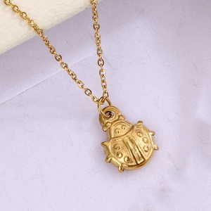 Vue détaillée d'un pendentif coccinelle plaqué or sur une fine chaîne dorée