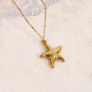 Détail macro d'un pendentif étoile de mer plaqué or 14K avec une finition de surface texturée