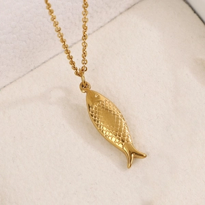 Détail macro d'un collier pendentif poisson plaqué or 14K aux écailles texturées