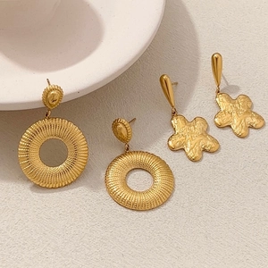 Boucles d'oreilles étoiles et fleurs en acier doré avec finitions martelées et texturées