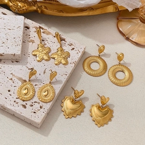 Vier Paar stern- und herzförmige goldene Ohrringe auf edlem Stein und Rahmen präsentiert