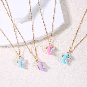 Close-up of dolphin pendant necklaces in pastel enamel colors and gold plated chains