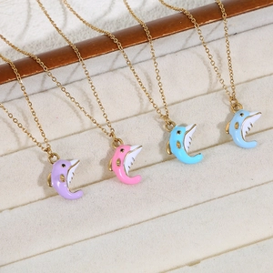 Detail view of colorful dolphin enamel pendants on gold chains on a jewelry display