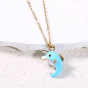 Detailed macro view of a light blue dolphin pendant necklace on a textured white rock