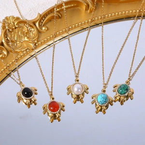 Gros plan de pendentifs tortue avec pierres colorées et strass sur un miroir
