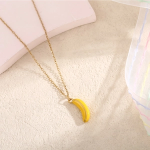 Dettaglio ravvicinato di una collana a catena dorata con pendente a forma di banana
