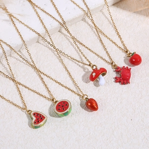 Golden necklace set with colorful enamel charms like strawberry, watermelon and mushroom