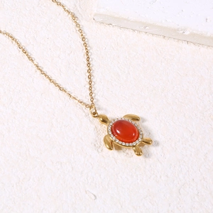 Vue détaillée du collier tortue avec pierre précieuse rouge et cristaux brillants