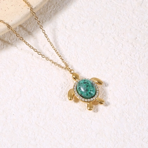 Détail du collier pendentif tortue dorée avec pierre naturelle verte et cristaux brillants