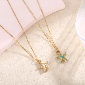 Starfish pendant necklaces in gold finish with white and teal enamel on o-link chains