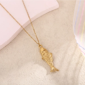 Vue détaillée d'un pendentif carpe koi dorée avec écailles fines sur collier à maillons
