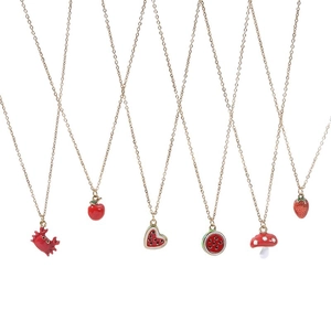 Golden chain necklaces with red enamel fruit and animal pendants on a white background