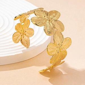 Macro shot of gold vintage floral bangle with detailed petal texture and metallic finish