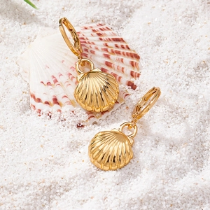 Golden shell hoop earrings featuring radial texture for a stylish beach vacation look