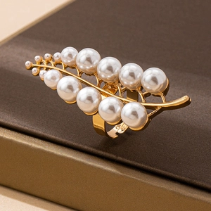 Close-up of a gold leaf-shaped open ring adorned with small white pearls