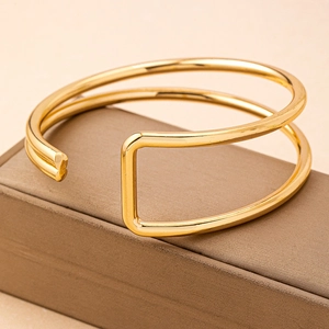 Minimalist double-layered gold geometric open bangle bracelet displayed on a luxury jewelry box