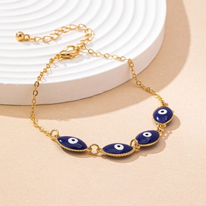 Detailed view of adjustable gold chain bracelet featuring four blue Evil Eye charms