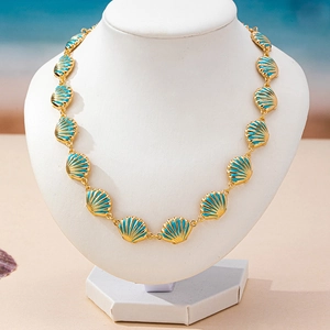 Golden shell necklace with turquoise enamel pendants for beach style on white mannequin