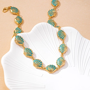 Detail of gold chain necklace with turquoise shell pendants and a lobster clasp closure