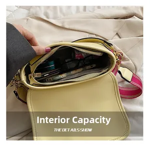 Détail du compartiment intérieur spacieux du sac bandoulière beige avec articles du quotidien