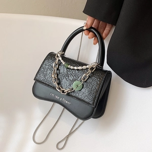 Chic black textured leather handbag with pearl chain detail and floral slogan print