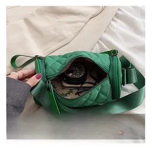 Interior view of green quilted nylon barrel bag showing phone and jewelry storage space
