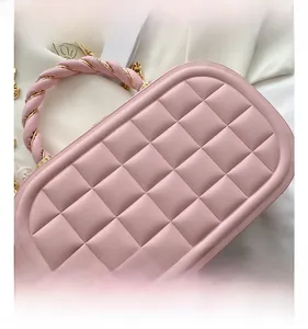 Detail of pink quilted handbag with diamond stitching and leather chain handle