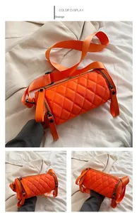 Detail view of orange quilted nylon barrel bag with wide strap and zip closures