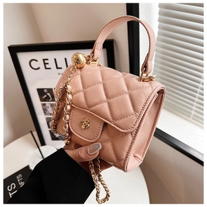 Close-up of light pink quilted mini bag with gold camellia clasp and chain strap detail
