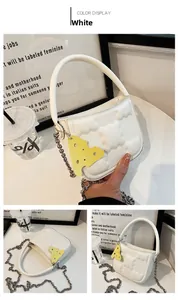 Detail der weißen Puffer-Mini-Tasche mit Puffy-Textur und gelbem Käse-Anhänger-Detail