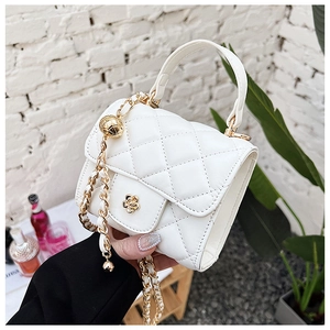 Macro shot of white quilted mini bag with golden camellia buckle and chain strap