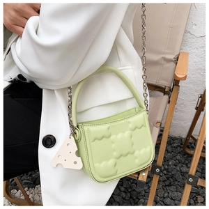 Detailansicht der hellgrünen Keks-Handtasche mit Wolkentextur und Käse-Anhänger