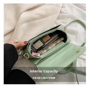 Détail de l'intérieur du sac vert montrant l'espace pour téléphone et parfum
