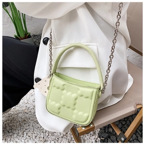 Detail einer hellgrünen 3D-Cloud-Tasche mit Silberkette, getragen von einem Modell