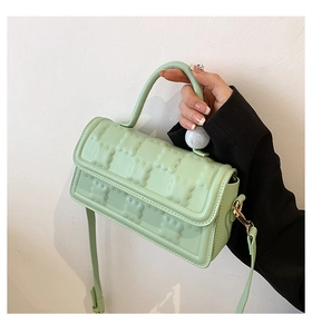 Détail du sac bandoulière vert menthe avec gaufrage texturé et perle marbrée décorative
