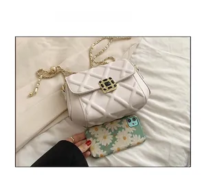 Detail der cremefarbenen Stepptasche mit goldener Kette und Smartphone zum Größenvergleich