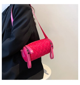 Chic quilted nylon barrel bag in bright pink shown on model with wide shoulder strap
