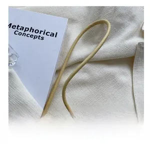 Détail de la bandoulière en cuir crème avec nœud et finitions métalliques dorées