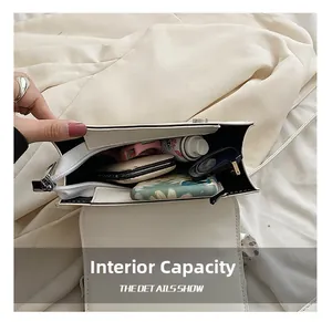 Internal capacity of white square crossbody bag showing sunglasses and makeup items