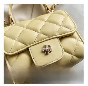 Detailed macro view of the cream quilted crossbody bag with a gold floral clasp