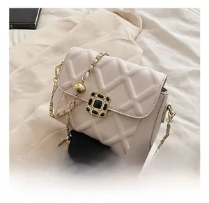 Nahaufnahme der cremefarbenen Stepptasche mit goldener Kette und Metalldetail