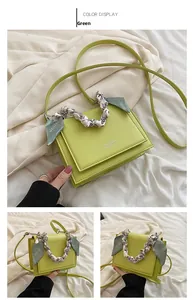 Close-up of green crossbody square bag with silk scarf handle and white logo detail