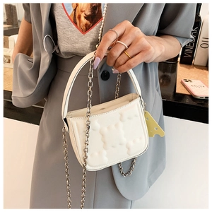 Detail der weißen gesteppten Tasche mit Silberkette und süßem Käse-Anhänger Zubehör