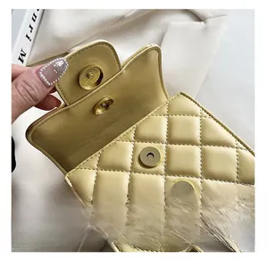 Detail showing the secure golden magnetic snap closure on a yellow quilted chain bag