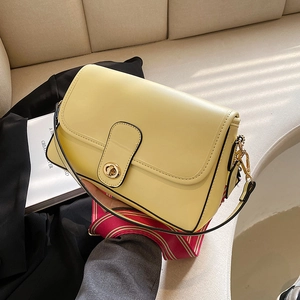 Sac bandoulière beige élégant avec fermoir doré et sangle tissée à rayures