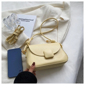 Détail du petit sac carré crème en similicuir avec bandoulière à nœud et boucle mate