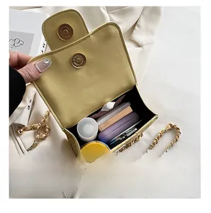 Internal storage view of the green quilted chain cloud bag showing lipstick and cosmetics