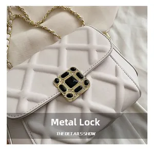 Nahaufnahme des eleganten Metallschlosses mit schwarzem Edelstein auf gesteppter Tasche